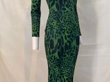 a green and black leopard print dress on a mannequin base