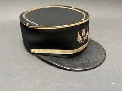 un chapeau noir orné d'une bordure dorée sur fond gris