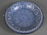 blue and white bowl with a circular design on the rim