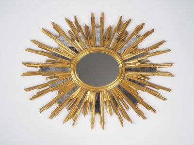 un miroir doré en forme d'étoile accroché au mur