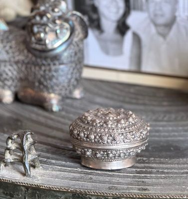 two silver figurines sitting on top of a wooden table