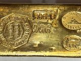 gros plan d'un lingot d'or sur une surface blanche