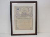 un vieux certificat est accroché au mur, devant un mur blanc