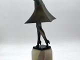 statue of a woman in a dress and hat on a marble base