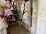 two tall vases with flowers in them on the floor