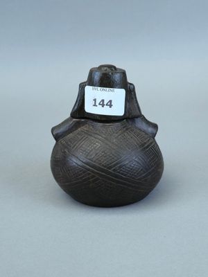 une image représentant un petit vase noir sur lequel est accrochée une étiquette