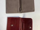 two leather wallets on a white table with one open and the other closed