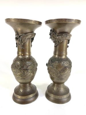 two metal vases sitting on top of each other