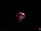 a close up of a red diamond on a black surface