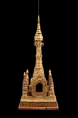 une statue dorée représentant une pagode sur fond noir