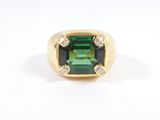 a close up of a green tourmaline and diamond ring on a white background