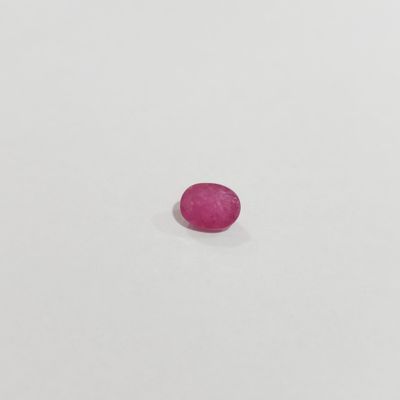 a single pink stone sitting on top of a white surface