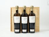 trois bouteilles de vin dans un coffret en bois sur une surface blanche