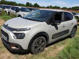 une petite voiture blanche garée dans un champ d'herbe