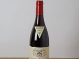 a bottle of red wine sitting on a wooden table