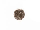 an old coin with a face on it sitting on top of a white surface