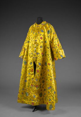 une robe en soie jaune ornée de fleurs et de feuilles