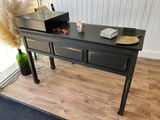 a black desk with a computer on top of it