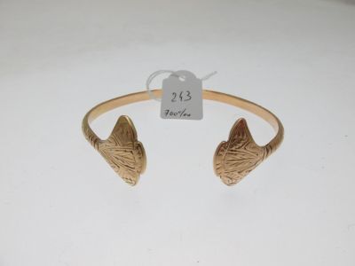 un gros plan sur un bracelet en or orné d'une tête de chat