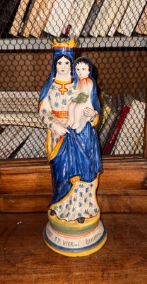 une statue de femme tenant un enfant sur une table