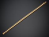 un bracelet en or orné de perles sur fond noir