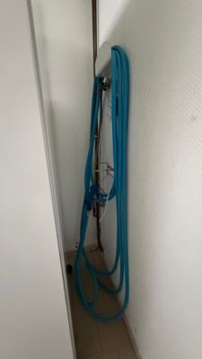 un tuyau bleu situé à côté d'un mur blanc