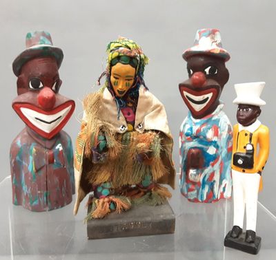 three figurines of different people on display