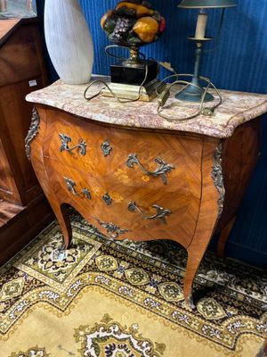 une petite table sur laquelle se trouve un vase, dans une pièce