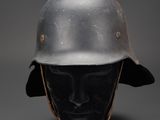 an old helmet on a mannequin head on a grey background