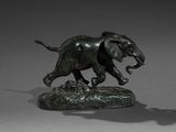 bronze statue of an elephant with tusks running on a rock