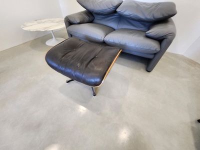 a black leather couch and ottoman in a living room