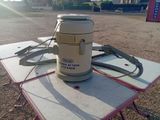 une petite table sur laquelle se trouve un aspirateur, au milieu d'un parking