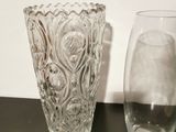 a glass vase next to a glass vase on a table