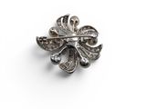 a close up of a silver broochle on a white background