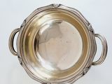 a silver bowl with handles on a white table