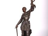 statue en bronze représentant un homme tenant une épée et un oiseau