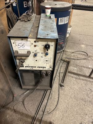 a machine that is sitting on the ground next to a barrel