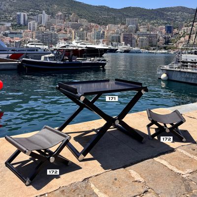 une table et deux chaises sur le quai, au bord de l'eau