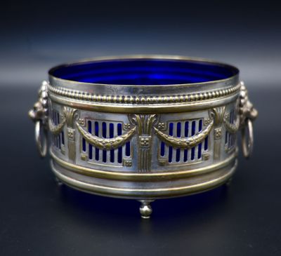 an antique silver and blue glass bowl sitting on a black surface