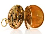 a close up of a pocket watch on a white surface