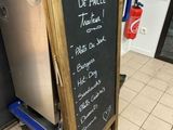 a chalk board with a menu written on it in front of a refrigerator
