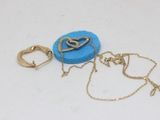 Deux bijoux sont posés sur une surface blanche