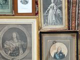 many framed pictures on the wall of a room