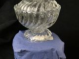 a glass bowl with a lid sitting on a rock