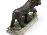 statue of a lion on a pedestal with a ball in its mouth