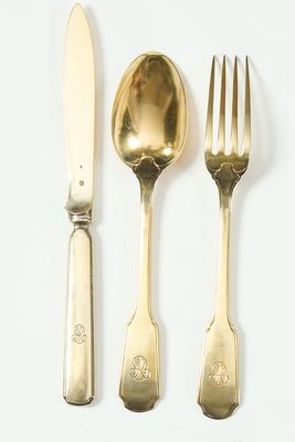 trois fourchettes, une cuillère et un couteau posés sur une surface blanche