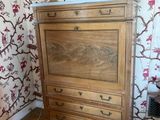 a dresser in the corner of a room with a lamp on it