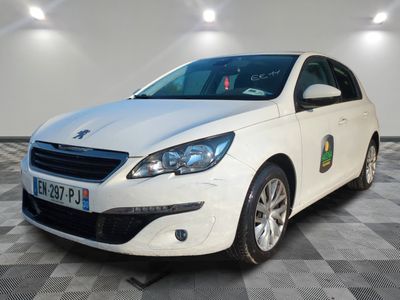 La voiture blanche est garée sur le sol à damier du garage.