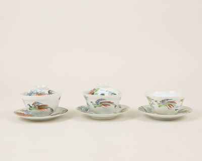 three cups and saucers with birds on them on a white surface