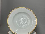 three white plates with gold rims are stacked on top of each other